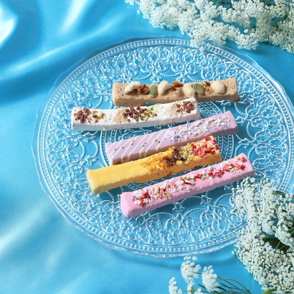 Five decorated Le Stick Rusk sticks on a glass plate
