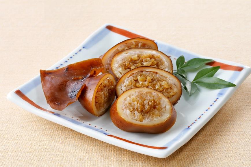 Sliced ikameshi on a Japanese plate showing rice-filled squid cross sections