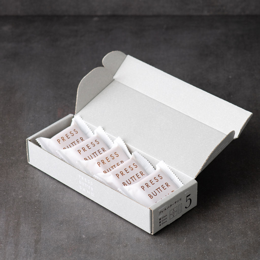 Open PRESS BUTTER SAND box with five wrapped sandwiches