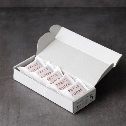 Open PRESS BUTTER SAND box with five wrapped sandwiches