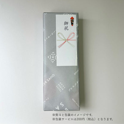 PRESS BUTTER SAND box with gift wrapping and celebration label (illustrative)